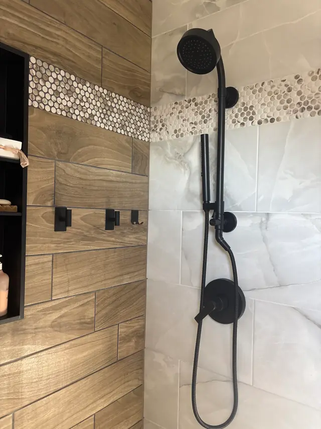 Finished shower with wood-look and marble-look tile, a penny-tile band and matte black fixtures